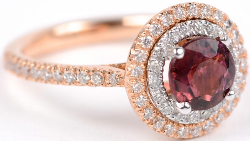 Een 18 karaats roze gouden ring bezet diamanten met een gezamenlijk gewicht van ± 0,50 ct. en een centrale toermalijn ± 1,20 ct. Naar een model van Tiffany.