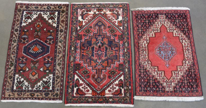 Drie verschillende handgeknoopte Oosterse wollen karpetjes.