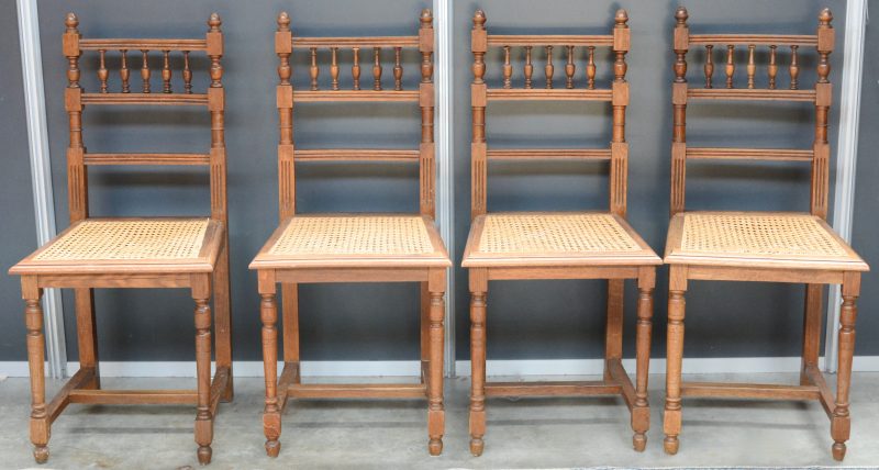 Vier stoelen van gesculpteerd eikenhout met vijf balustervormige spijlen in de rug en met gevlochten zit.