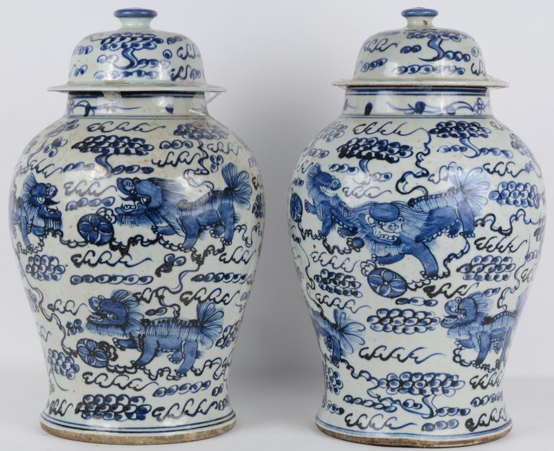 Een paar dekselvazen van Chinees porselein met een blauw en wit decor van Fo-honden.