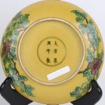 Een paar borden van Chinees porselein met een meerkleurig decor van granaatappels op gele fond, onderaan gemerkt.