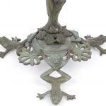 Een horloge- of juwelenhanger van groengepatineerd brons in de vorm van een boom met een fazant op een tak. De voet in de vorm van drie kikkers met leeuwenkopjes tussen de poten. Begin XXe eeuw.