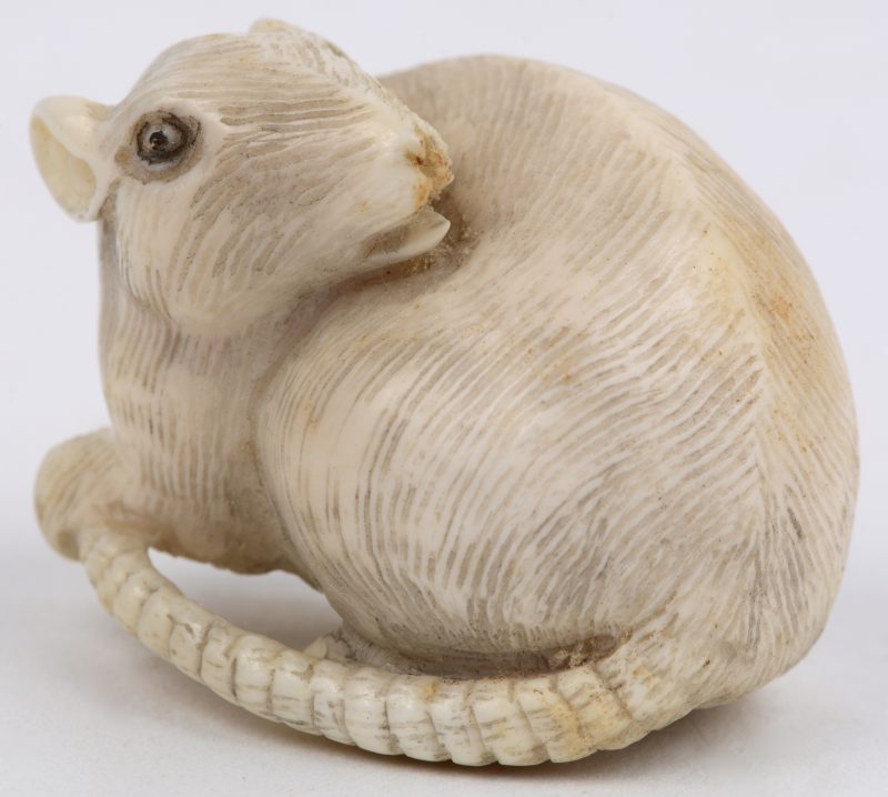 “Rat”. Een netsuké van ivoor. Japans werk, begin XXste eeuw. Onderaan gemerkt.
