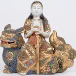 Een Boeddha een een Guan Yin op tempelleeuw van Satsuma-aardewerk.