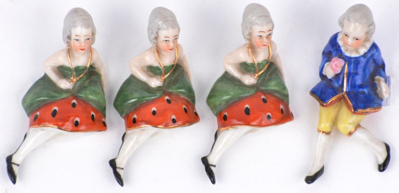 Vier miniatuur beeldjes van meerkleurig porselein, bestaande uit vier dametjes en een heertje.