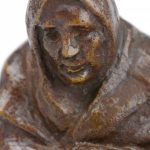 “Oude vrouw met mand”. Een beeldje van bruingepatineerd brons op houten sokkel. Gesigneerd.