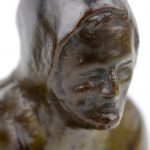 “Oude vrouw”. Een bronzen beeldje op arduinen voetstuk.