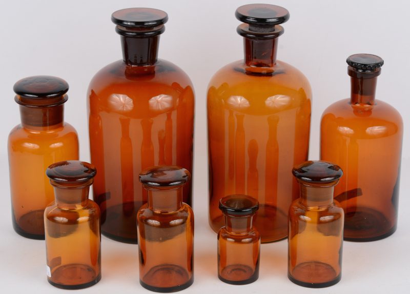Een lot van acht apothekersflessen van bruin glas in verschillende formaten.
