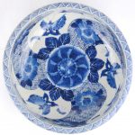 Een kom van Chinees porselein met een blauw en wit decor van vlinders en bloemen.