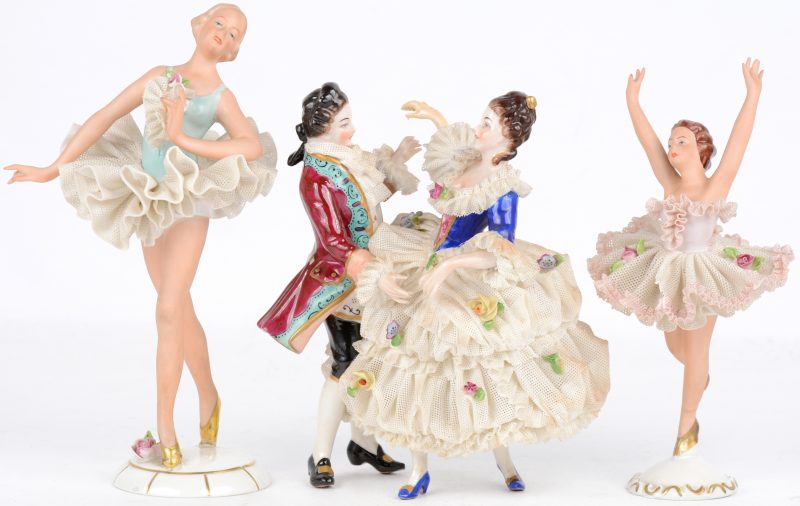 Drie beeldjes van meerkleurig porselein, bestaande uit twee ballerina's en een gropeje in de vorm van een dansend XVIIIe eeuws koppel. Allen gemerkt.