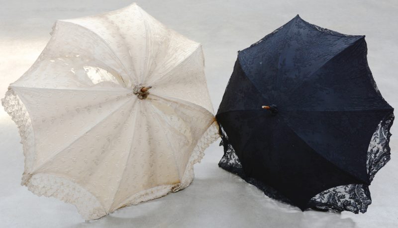 Twee antieke parasols van wit en zwart kant.