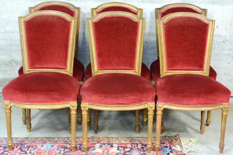 Serie van zes Lodewijk XVI-stijl stoelen van verguld hout en bekleed met bordeauxrood fluweel.