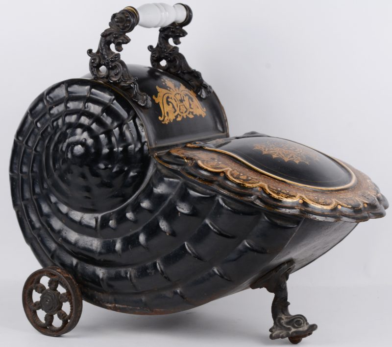Een schelpvormige turfbak van zwartgelakt metaal met verguld decor met een geëmailleerd handvat. Tijdperk Napoleon III.