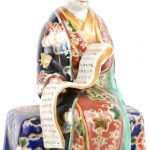 Een zittende figuur en een kom van meerkleurig Chinees porselein.