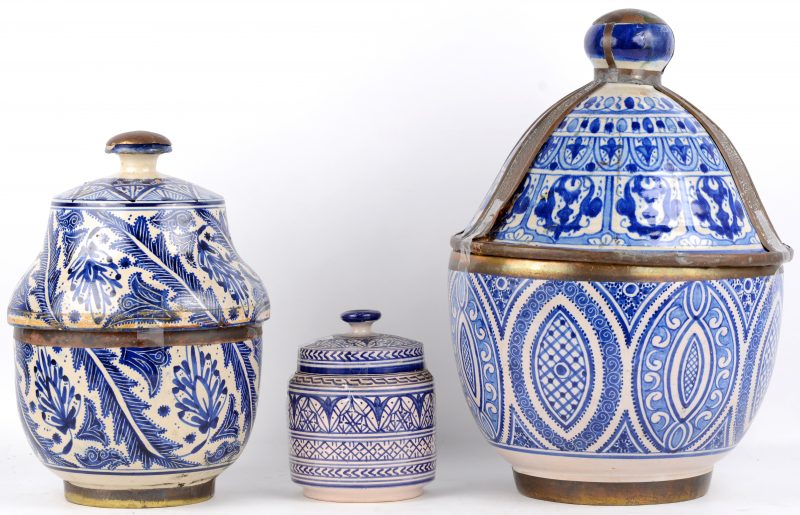 Drie aardewerken potten met blauw en wit decor.