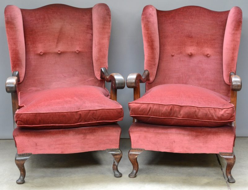 Een paar notenhouten wingchairs met roze fluwelen bekleding.