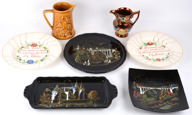 Een lot meerkleurig aardewerk, bestaande uit drie verschillende schotels van Longwy, een paar borden met spreuken en twee verschillende schenkkannetjes.
