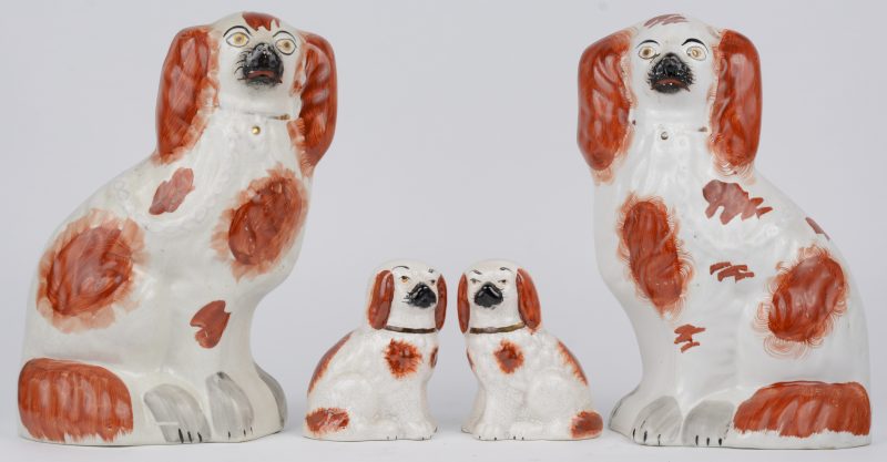 Een lot hondjes van Stafforshire-aardewerk, bestaande uit twee grote en twee kleine. Eén grote met barsten.