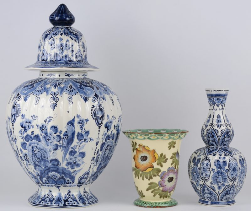 Een lot aardewerk bestaande uit een grote dekselvaas  (H. 54 cm) en een kalebasvaas (H. 31 cm) met blauw en wit decor. Evenals een vaas van Gouda plateel met ajour rand (H. 19 cm). Alle stukken onderaan gemerkt.