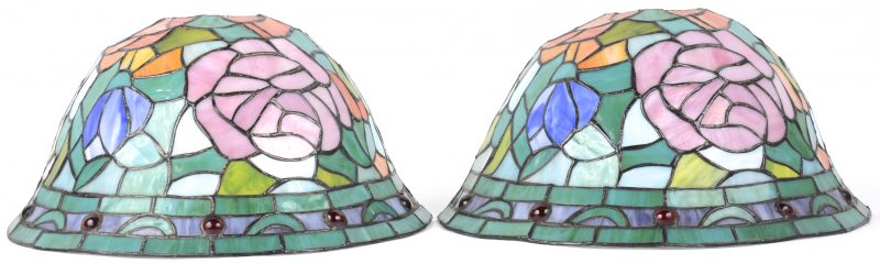 Een paar wandlampen met kapjes van glas in lood in de geest van Tiffany’s.
