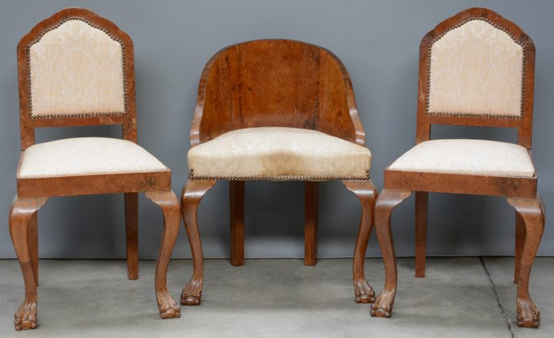 Twee stoelen van wortelnootfineer en een kuipstoeltje met dezelfde bekleding.