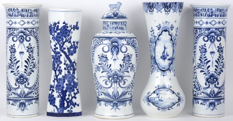Een lot blauw en wit aardewerk, bestaande uit een driedelig kaststel, een Delftse vaas en een vaas met bloesems.