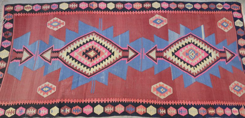 Een groot handgeweven Kelim-tapijt.