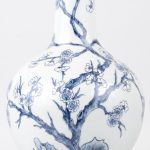 Een buikvaas van Chinees porselein met een blauw en wit decor van en bloesemende struik. Gemonteerd als lampvoet met messingen montuur en voet.