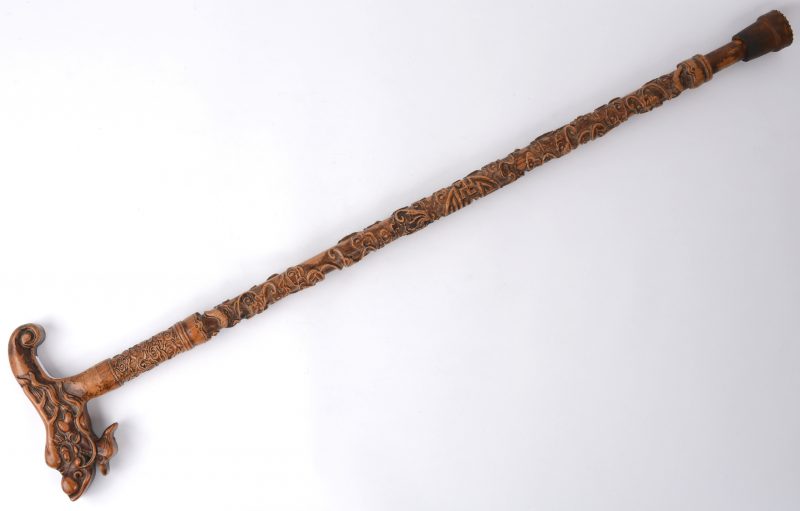Een Chinese wandelstok van gesculpteerd hout met een handgreep in de vorm van een draak.