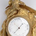 Een barometer van verguld brons, gedragen door Chronos en bovenaan getooid met een engeltje.