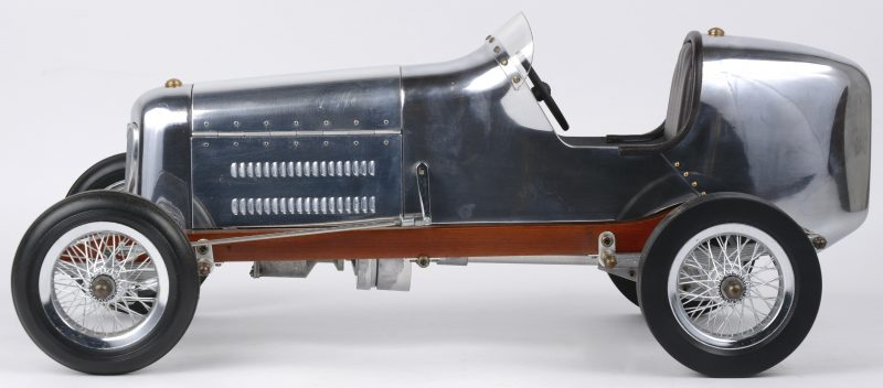 Een aluminium schaalmodel van een vroege racewagen.