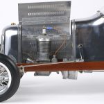 Een aluminium schaalmodel van een vroege racewagen.
