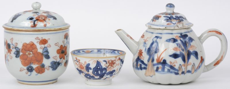 Een Imari theesetje, bestaande uit een theepot, een suikerpot en een kommetje. Enkele haarscheuren en kleine beschadigingen. Eind XIXe eeuw.