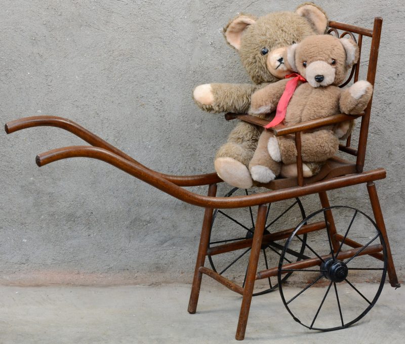 Een speelgoedwagentje met twee teddyberen.