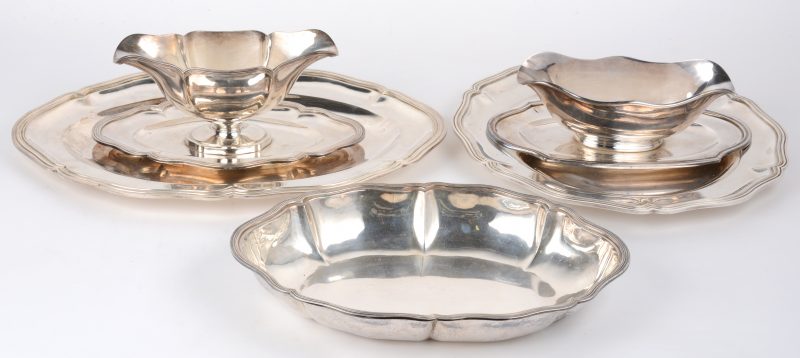 Een lot zilver, bestaande uit twee sauskommen, een ronde en een ovale schaal en een schotel. Merken van Wolfers en Delheid.