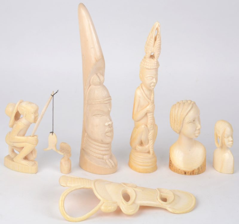 Een lot Afrikaans ivoor, bestaande uit drie verschillende bustes, twee figuren, een visser en een klein maskertje.