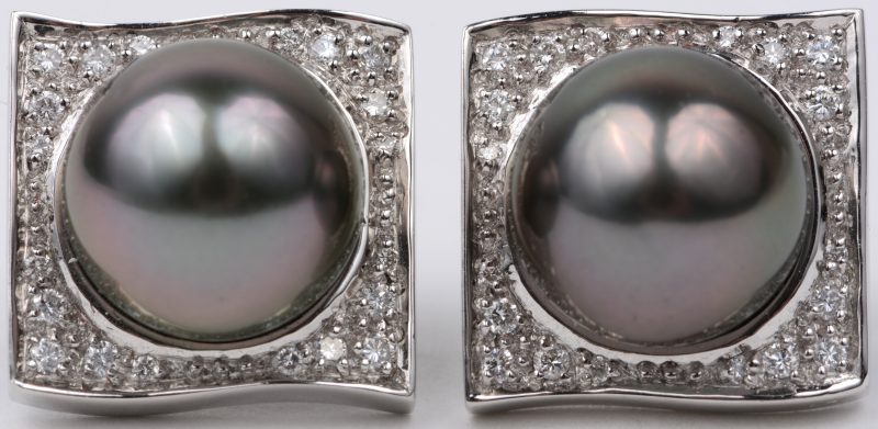Een paar 18 karaats witgouden oorbellen bezet met briljanten met een gezamenlijk gewicht van ± 0,33 ct. en twee grijze Tahitiparels van 10,6 mm.