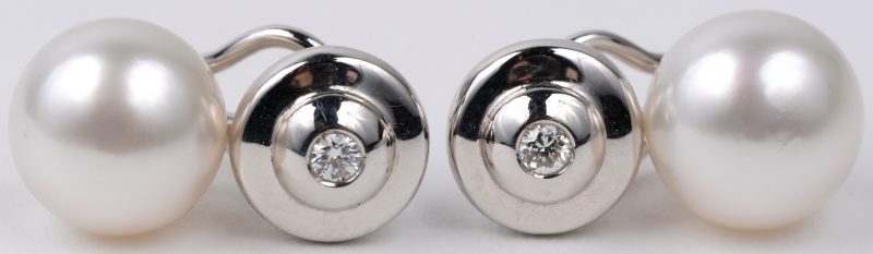 Een paar 18 karaats witgouden oorbellen bezet met briljanten met een gezamenlijk gewicht van ± 0,14 ct. en twee South Sea parels van 10,8 mm.