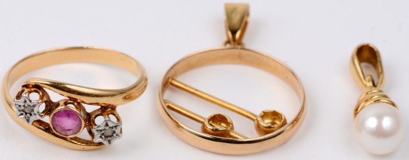 Twee verschillende 18 karaats geel gouden hangers bezet met briljant en een parel. We voegen er een 18 karaats geel gouden ring bezet met briljant en een robijn aan toe.