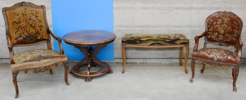 Twee verschillende fauteuils à la reine van gesculpteerd notenhout in Régencestijl. We voegen er een bankje en een ronde salontafel aan toe.