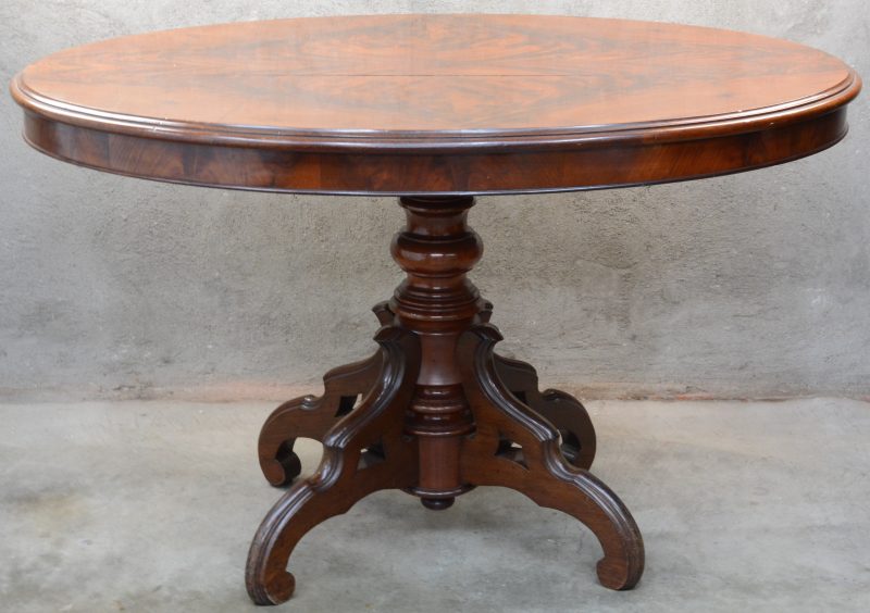 Een mahoniehouten ovale tafel met centrale gesculpteerde vierpoot. Tijdperk Louis Philippe. Barst in blad.
