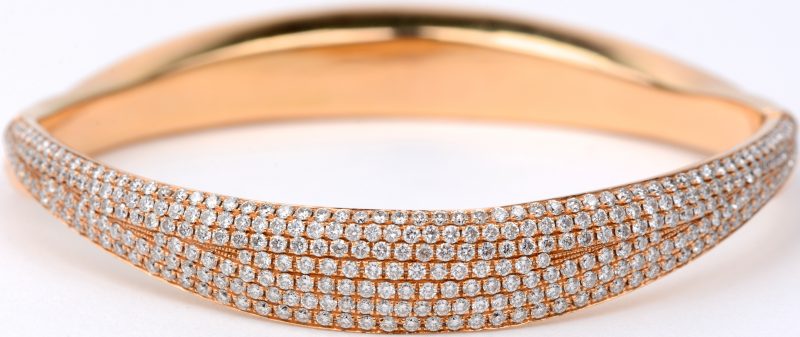 Een 18 karaats roze gouden slavenarmband vooraan bezet met diamanten met een gezamenlijk gewicht van ± 2,60 ct.