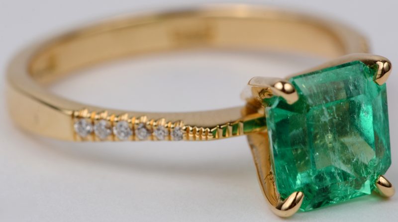 Een 18 karaats geel gouden ring bezet een centrale smaragd van ± 1,76 ct. met briljanten met een gezamenlijk gewicht van ± 0,10 ct. Met certificaat.