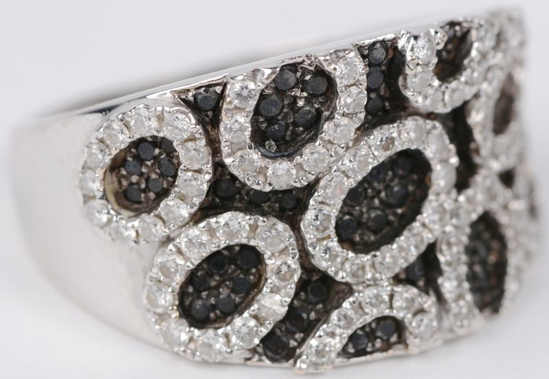 Een 18 karaats wit gouden ring bezet met witte en zwarte diamanten met een gezamenlijk gewicht van ± 1 ct.