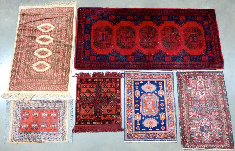 Een lot van zes wollen tapijtjes.