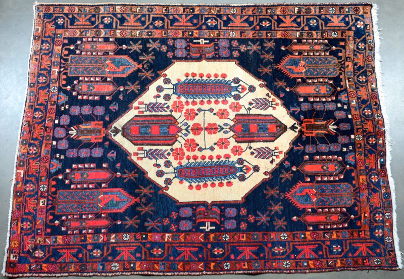 Een handgeknoopt Perzisch wollen tapijt. Slijtage.