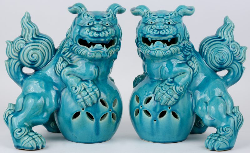 Een paar Fo-honden van lichtblauw geglazuurd porselein. Chinees werk, onderaan gemerkt.
