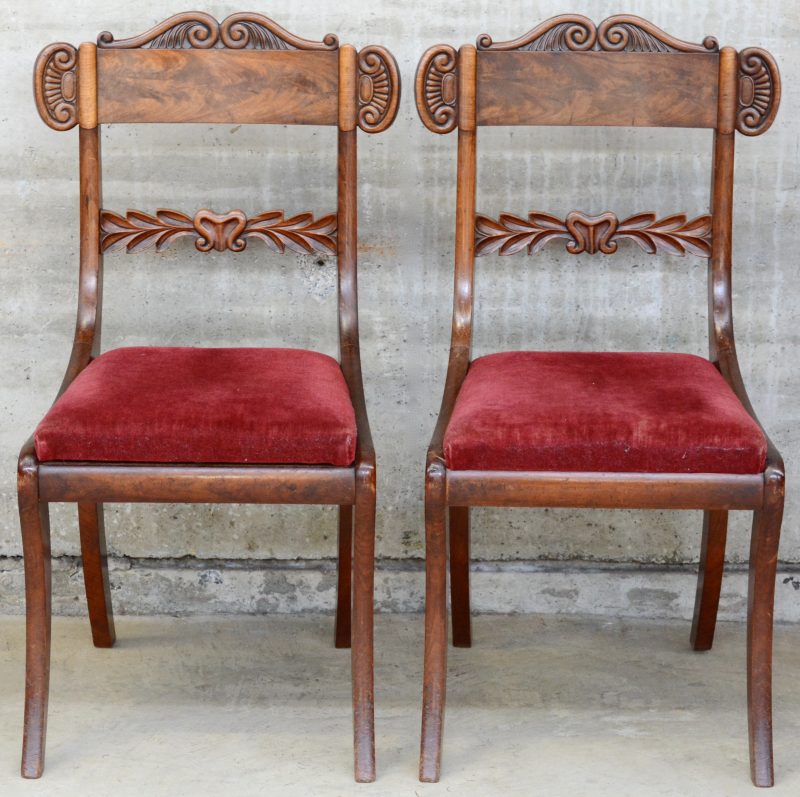 Twee mahoniehouten stoelen in regencystijl, bekleed met rood fluweel.