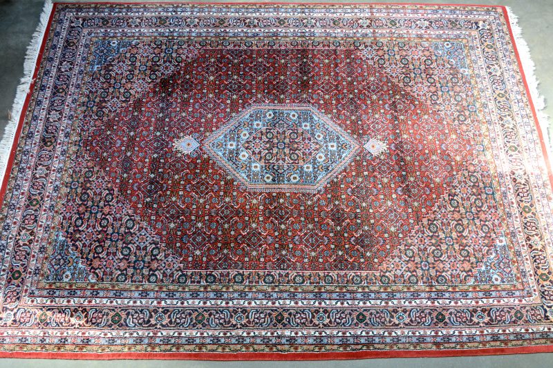 Een Oosters wolen tapijt met een centraal zeshoekig medaillon.