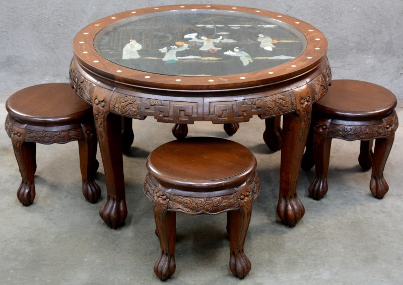 Een lage Chinese ronde tafel met een decor van Geisha”s van piëtra dura in het blad en met vier ronde stoeltjes.
